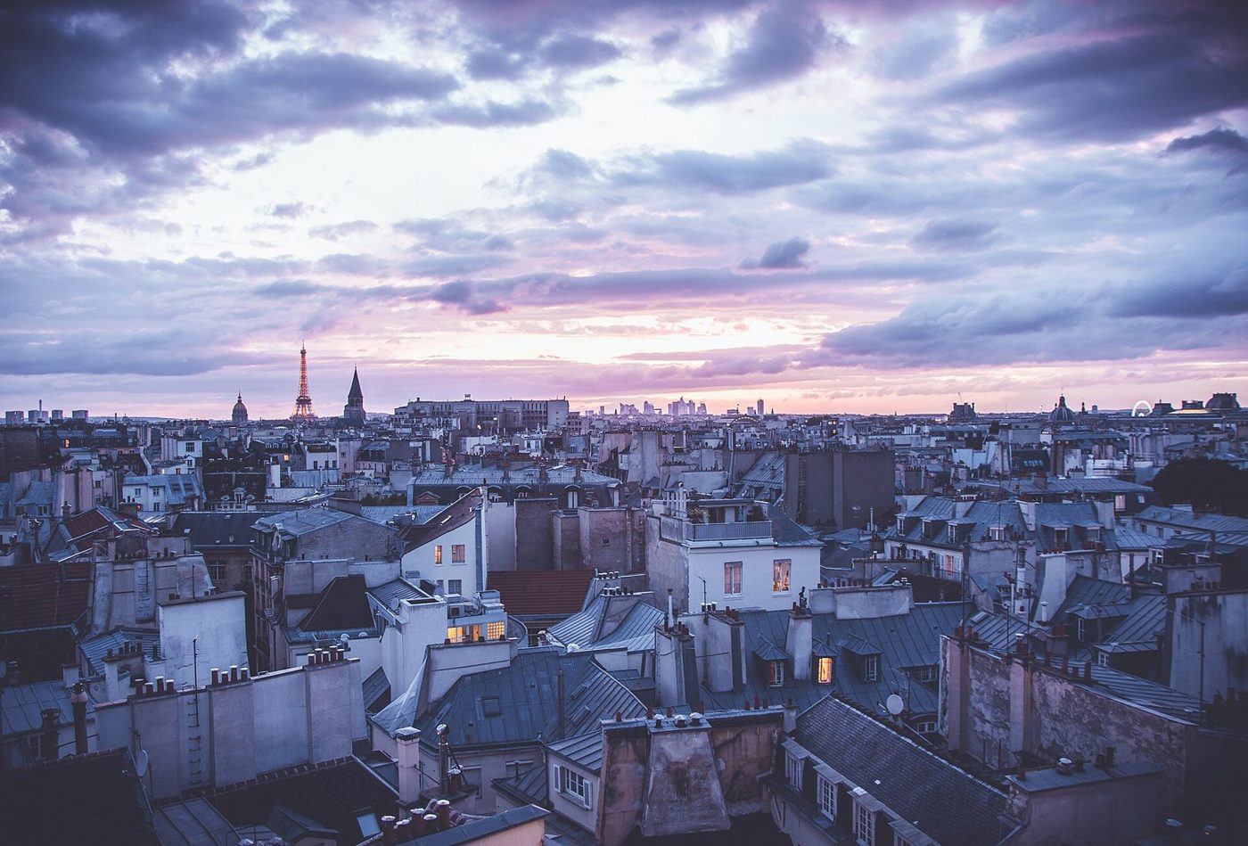 Paris rooftops at dusk with the Eiffel Tower in the distance